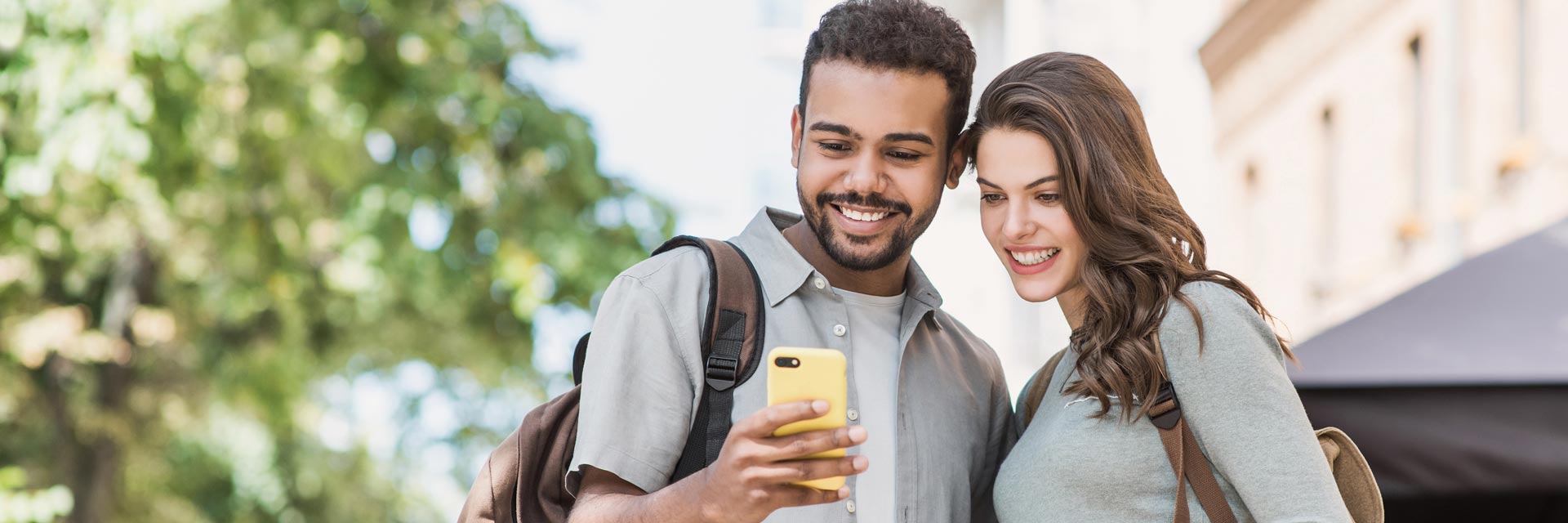 This is an image of a happy young couple looking at a smartphone.