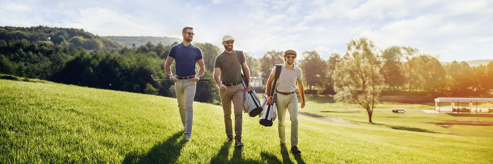 This is an image of three men walking confidently with their golf clubs on a golf course.